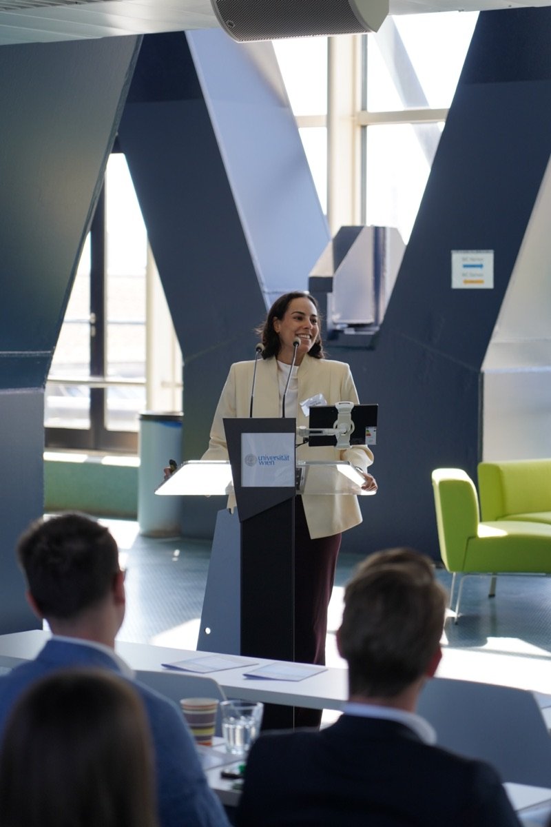 Vortragende in weißem Blazer bei einer Konferenz